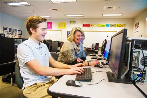 Student on computer with teacher 